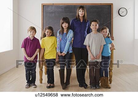 Teacher with group of pupils in front of blackboard View Large Photo Image Stock Photo - Teacher with group of pupils in front of blackboard. Fotosearch