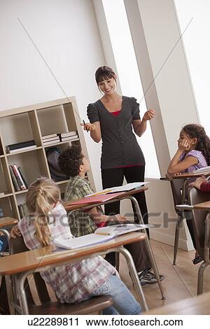 Stock Image - Teacher with schoolchildren (6-7, 8-9). Fotosearch