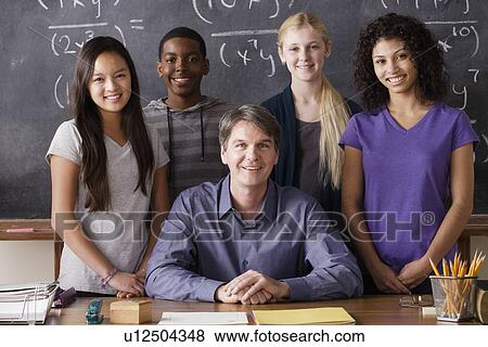 Stock Photo - Teacher with teenage students (14-15, 16-17) at school. Fotosearch