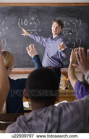 Stock Photo - Teacher with teenage students (14-15, 16-17) at school. Fotosearch