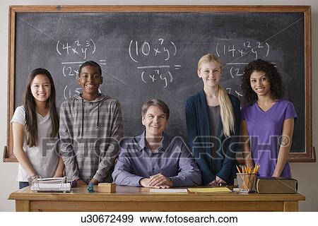 Stock Photo - Teacher with teenage students (14-15, 16-17) at school. Fotosearch