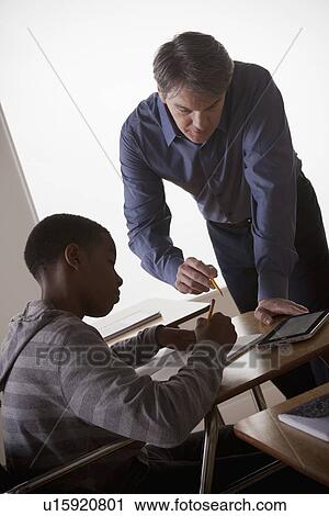Teenage boy (14-15) with teacher at school View Large Photo Image Stock Image - Teenage boy (14-15) with teacher at school. Fotosearch