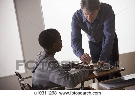Teenage boy (14-15) with teacher at school View Large Photo Image Stock Photo - Teenage boy (14-15) with teacher at school. Fotosearch
