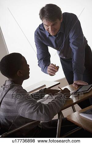 Teenage boy (14-15) with teacher at school View Large Photo Image Stock Photo - Teenage boy (14-15) with teacher at school. Fotosearch