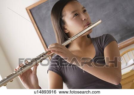 Stock Photograph - Teenage girl (14-15) playing flute. Fotosearch