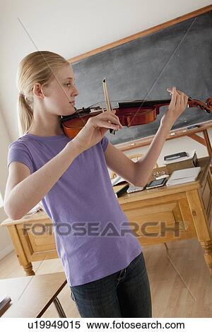 Stock Photography - Teenage girl (14-15) playing violin. Fotosearch