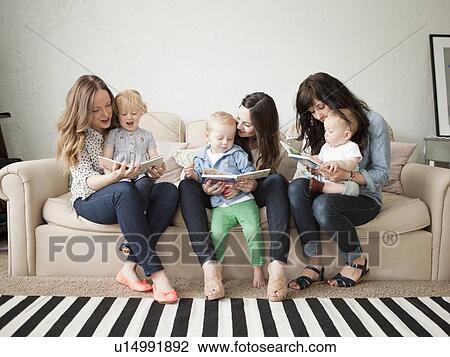 Stock Image - Three young mothers with toddler girl and boy (2-3) and baby boy (6-11 months). Fotosearch