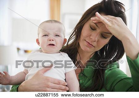 Tired mother holding baby daughter (6-11 months) View Large Photo Image Stock Photography - Tired mother holding baby daughter (6-11 months). Fotosearch