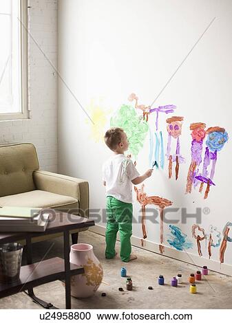 Stock Image - Toddler boy (2-3) painting on wall. Fotosearch