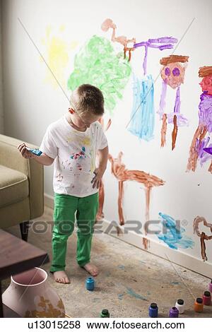 Stock Photo - Toddler boy (2-3) painting on wall. Fotosearch