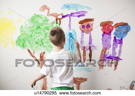 Stock Photography - Toddler boy (2-3) painting on wall. Fotosearch