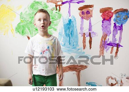 Toddler boy (2-3) standing in front of painted wall View Large Photo Image Stock Image - Toddler boy (2-3) standing in front of painted wall. Fotosearch