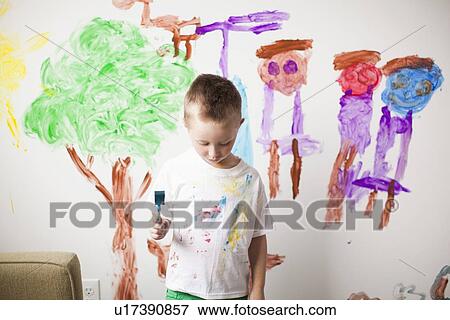 Toddler boy (2-3) standing in front of painted wall with guilt expression on his face View Large Photo Image Stock Photo - Toddler boy (2-3) standing in front of painted wall with guilt expression on his face. Fotosearch