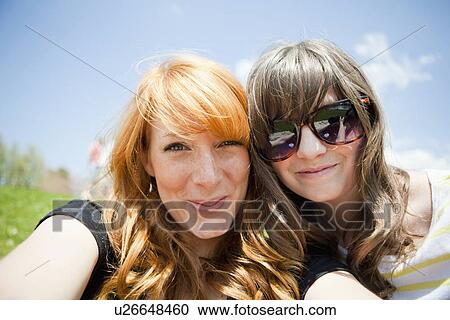Two young female friends posing for portrait View Large Photo Image Stock Image - Two young female friends posing for portrait. Fotosearch