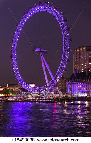 Stock Photo - UK, England, London, London eye illuminated at night. Fotosearch