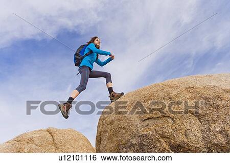 Stock Photograph - USA, California, Joshua Tree National Park, Female hiker on rocks. Fotosearch