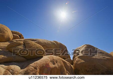 Stock Photography - USA, California, Joshua Tree National Park, Desert rocks with solar flare. Fotosearch