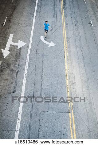 Stock Photograph - USA, California, Los Angeles, Elevated view of man and man running on street. Fotosearch