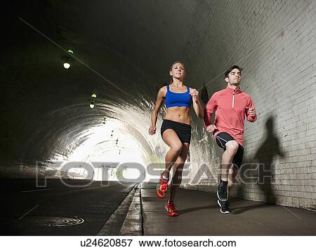 USA, California, Los Angeles, Young man and young woman running in tunnel View Large Photo Image Stock Photo - USA, California, Los Angeles, Young man and young woman running in tunnel. Fotosearch