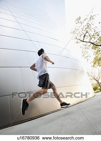 Stock Photograph - USA, California, Los Angeles, Young man running on city street. Fotosearch