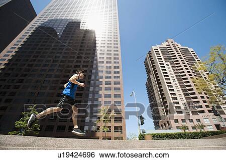 Stock Photograph - USA, California, Los Angeles, Young man running in city. Fotosearch