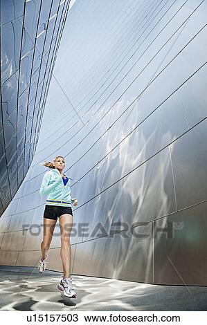 Stock Image - USA, California, Los Angeles, Young woman jogging in city. Fotosearch