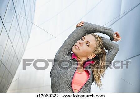 USA, California, Los Angeles, Young woman stretching near modern building View Large Photo Image Stock Image - USA, California, Los Angeles, Young woman stretching near modern building. Fotosearch