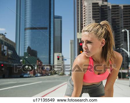 USA, California, Los Angeles, Young woman resting after running on city street View Large Photo Image Stock Photo - USA, California, Los Angeles, Young woman resting after running on city street. Fotosearch