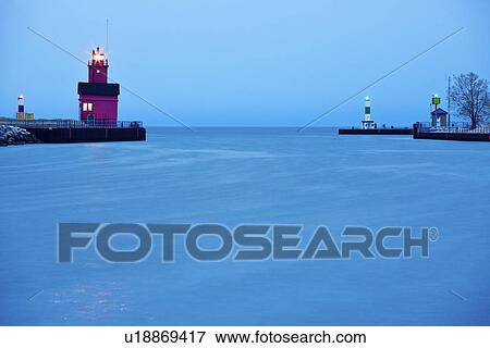 Stock Photo - USA, Michigan, Holland, Lighthouse at sunrise. Fotosearch