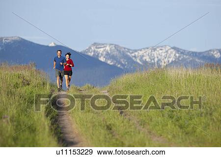 USA, Montana, Kalispell, Couple jogging in mountainside View Large Photo Image Stock Photo - USA, Montana, Kalispell, Couple jogging in mountainside. Fotosearch