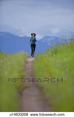 USA, Montana, Whitefish, Woman jogging on mountain path View Large Photo Image Stock Photo - USA, Montana, Whitefish, Woman jogging on mountain path. Fotosearch
