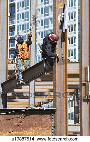 Picture - USA, New York, Long Island, New York City, Male workers on construction site. Fotosearch