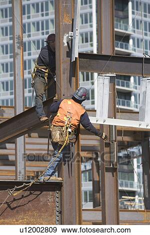 Stock Photo - USA, New York, Long Island, New York City, Male workers on construction site. Fotosearch
