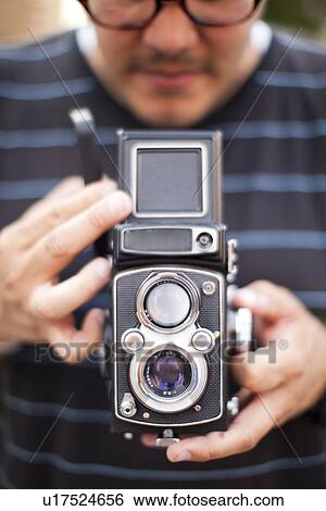 Stock Photograph - USA, New York State, New York City, Man holding old fashion camera. Fotosearch