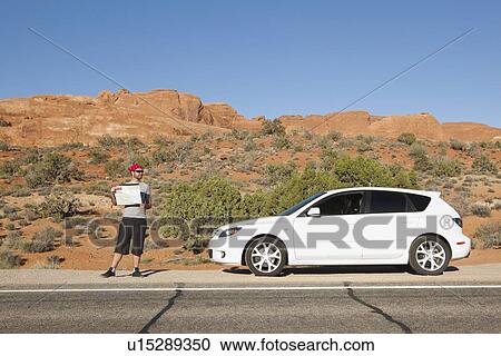 USA, Utah, Moab, Man standing beside car reading map View Large Photo Image Stock Image - USA, Utah, Moab, Man standing beside car reading map. Fotosearch