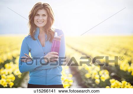 Stock Image - USA, Washington, Skagit Valley, Portrait of woman holding container. Fotosearch