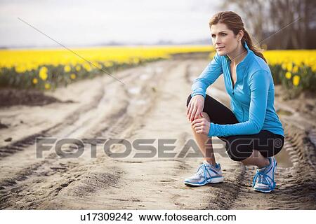 Stock Image - USA, Washington, Skagit Valley, Woman exercising in rural area. Fotosearch