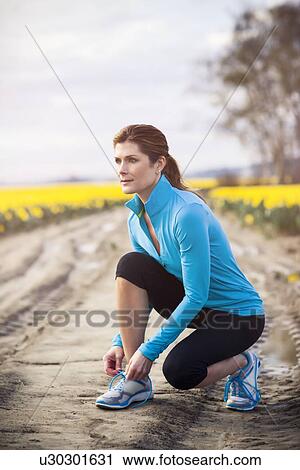 Stock Image - USA, Washington, Skagit Valley, Woman exercising in rural area. Fotosearch