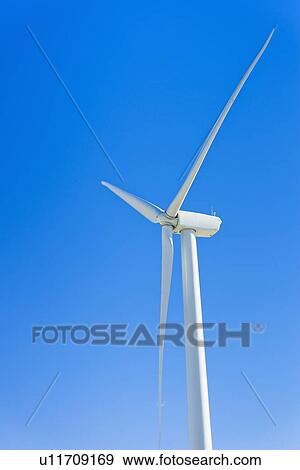 Stock Photo - Wind turbine against blue sky. Fotosearch