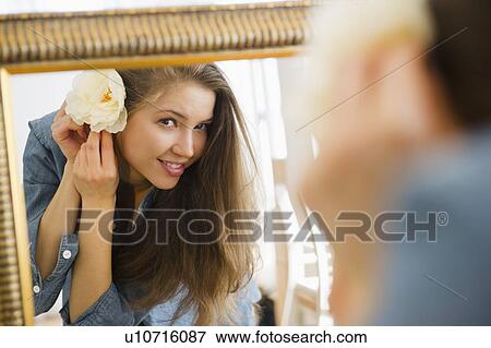 Woman adjusting flower in hair View Large Photo Image Stock Photo - Woman adjusting flower in hair. Fotosearch