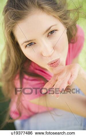 Woman blowing kiss towards camera View Large Photo Image Stock Photograph - Woman blowing kiss towards camera. Fotosearch