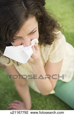 Woman blowing nose while sitting on lawn View Large Photo Image Stock Image - Woman blowing nose while sitting on lawn. Fotosearch