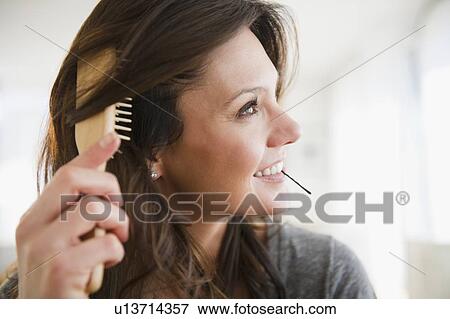 Woman brushing hair View Large Photo Image Stock Photo - Woman brushing hair. Fotosearch