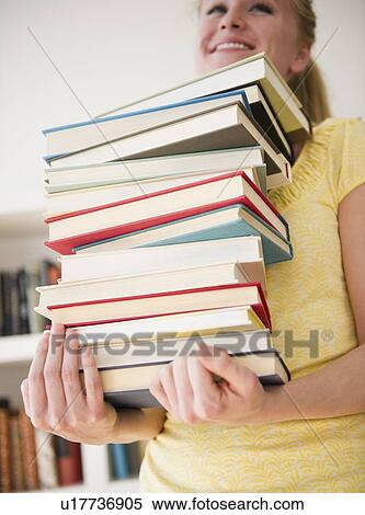 Stock Photography - Woman carrying stack of books. Fotosearch