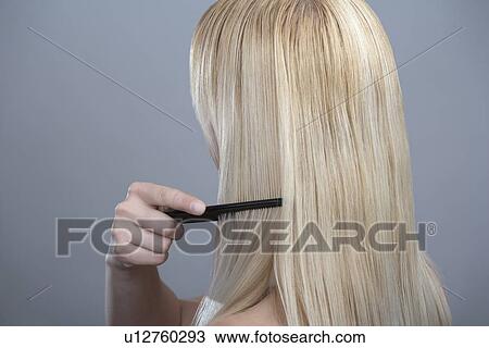 Woman combing hair, studio shot View Large Photo Image Stock Image - Woman combing hair, studio shot. Fotosearch