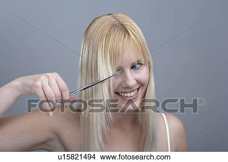 Woman cutting bangs, studio shot View Large Photo Image Picture - Woman cutting bangs, studio shot. Fotosearch
