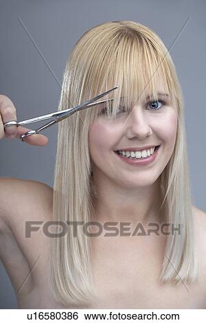 Woman cutting bangs, studio shot View Large Photo Image Stock Photograph - Woman cutting bangs, studio shot. Fotosearch