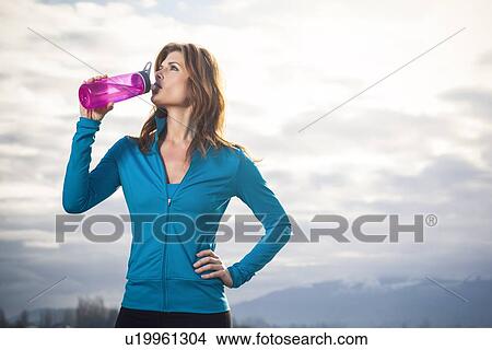 Woman drinking water after run View Large Photo Image Picture - Woman drinking water after run. Fotosearch