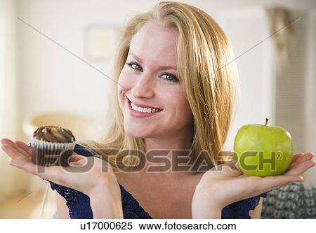 Woman holding apple and cupcake View Large Photo Image Stock Photography - Woman holding apple and cupcake. Fotosearch