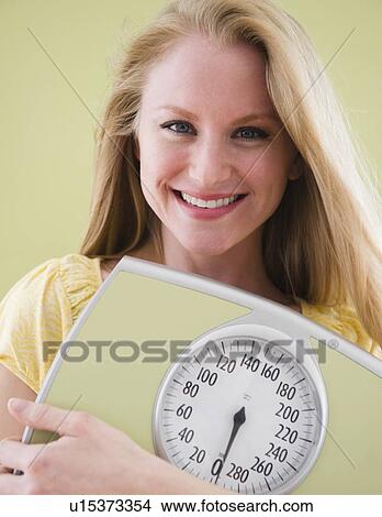 Woman holding bathroom scale View Large Photo Image Picture - Woman holding bathroom scale. Fotosearch